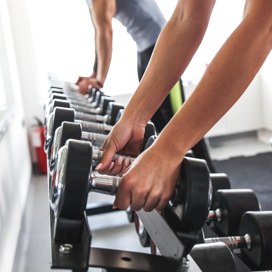 people at a dumbbell rack